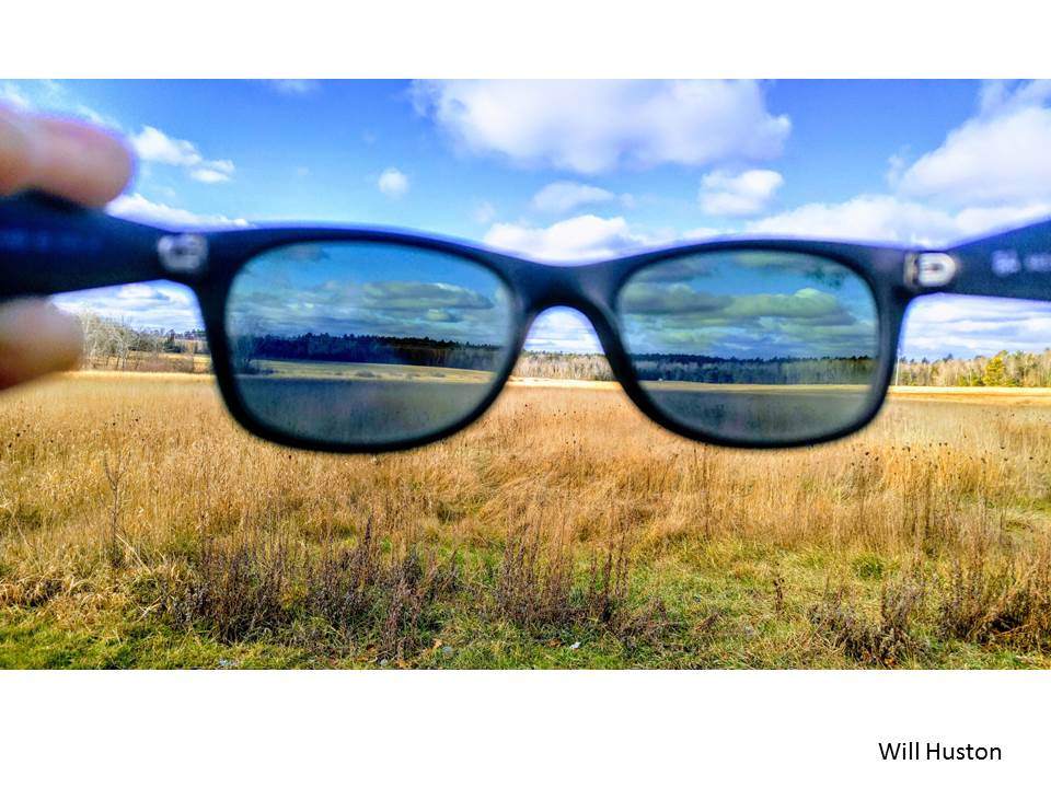 Stock photo view of a field with a pair of sunglasses held up in view